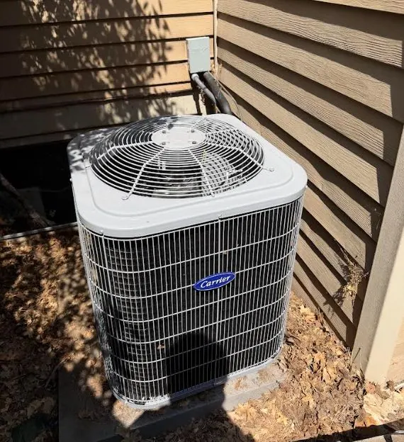 Carrier central air conditioner condenser beside a home
