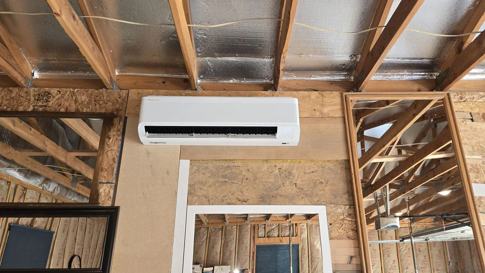 Ductless mini-split indoor unit mounted on a wall during a home build