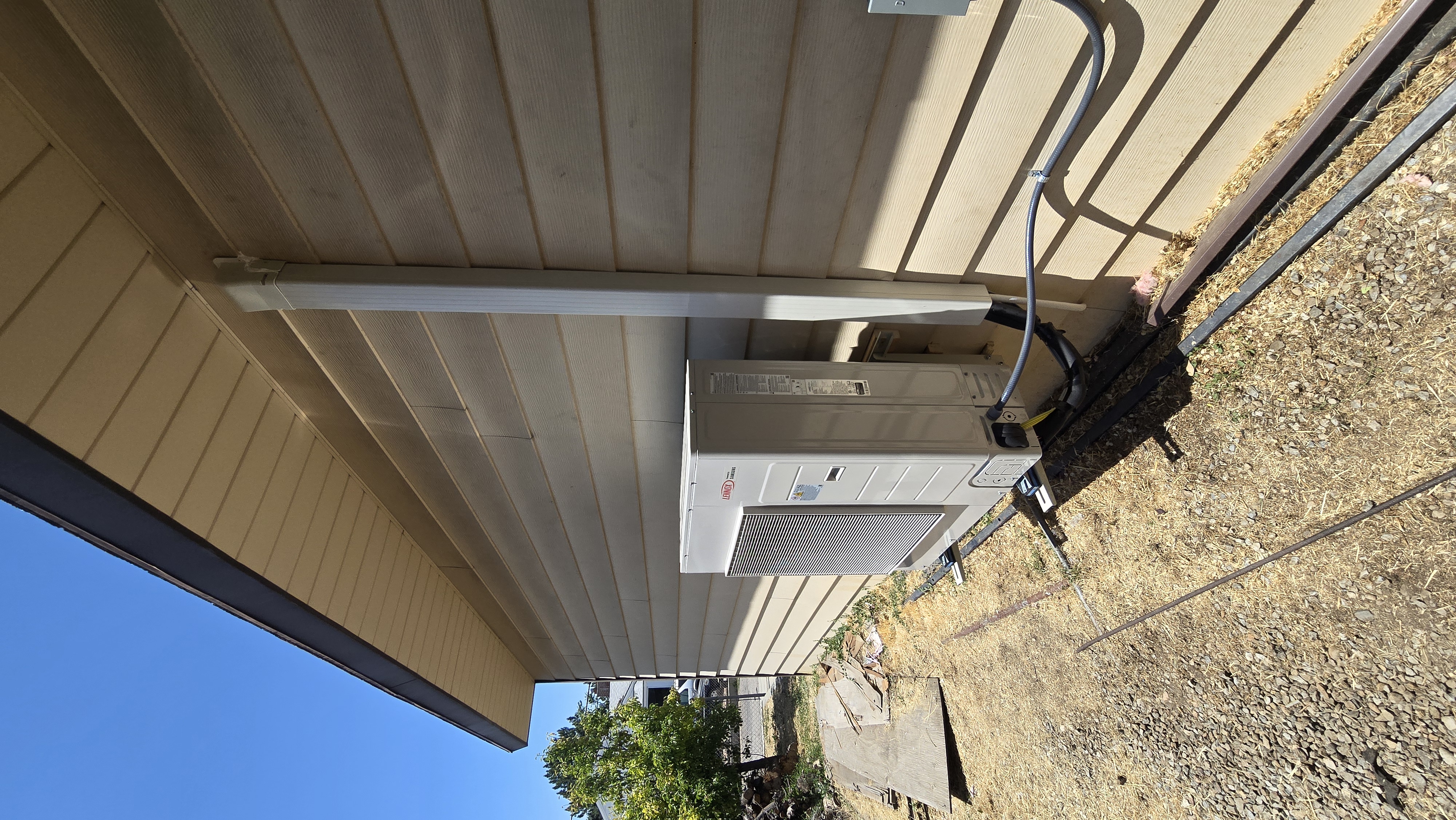 High-efficiency outdoor heat pump unit installed along exterior siding